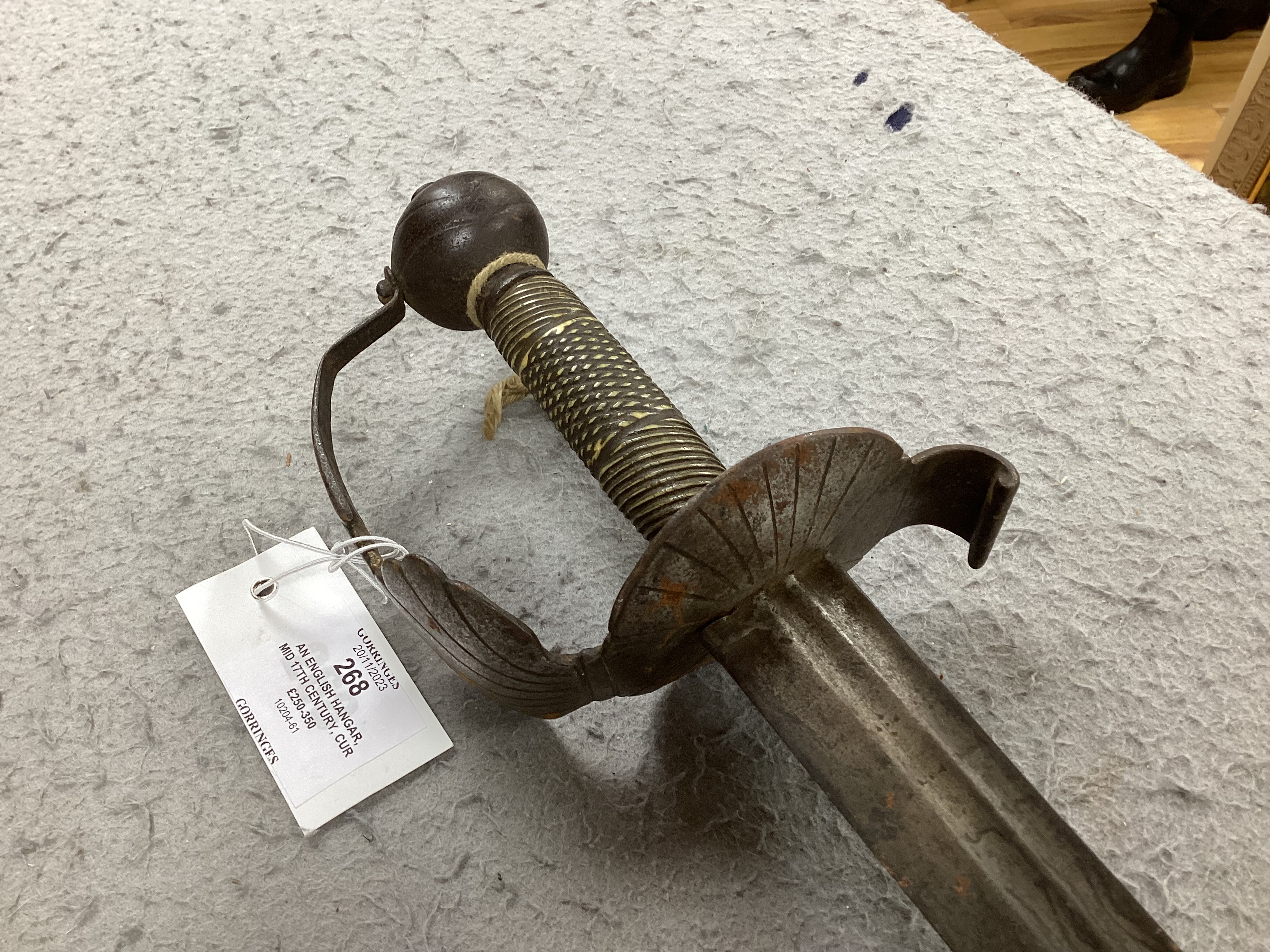 An English hangar, mid 17th century, curved fullered blade engraved with spurious date 1535 and running wolf mark, iron guard slightly reduced and swollen pommel, spirally carved and chequered bone grip, blade 67.5cm